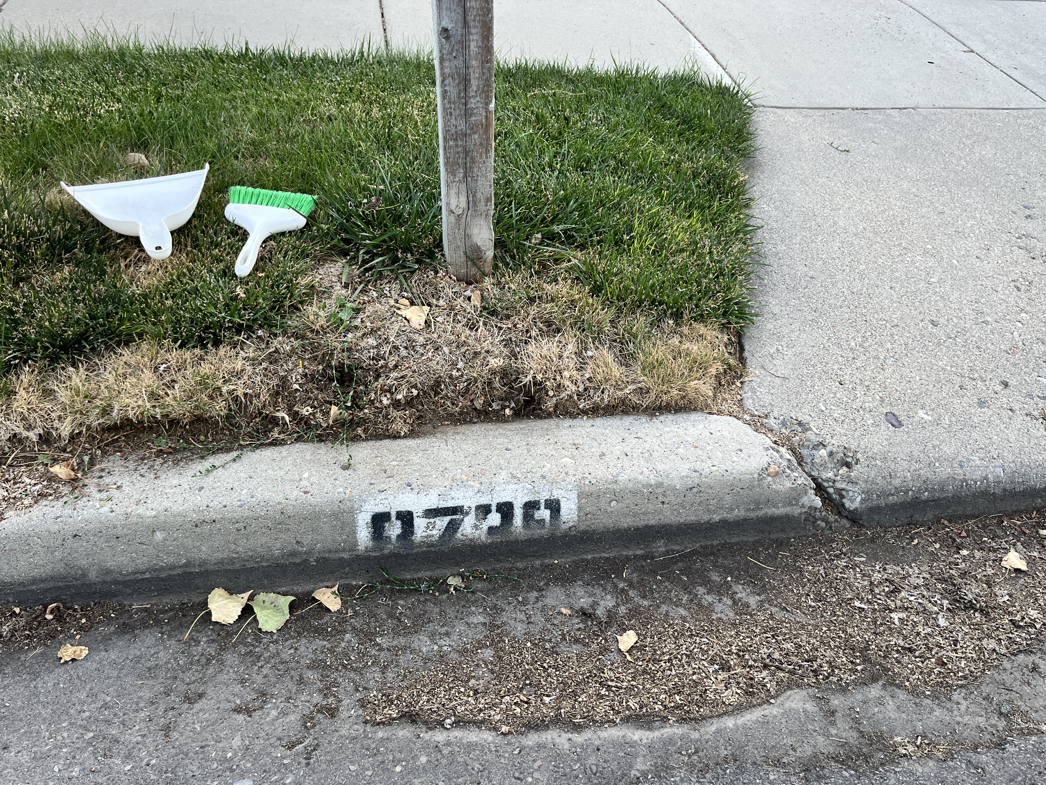 Before: faded black address numbers on a worn white curb background